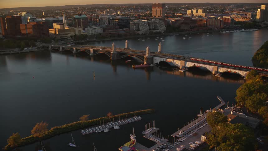 A bridge over a city river crossed by cars and a train