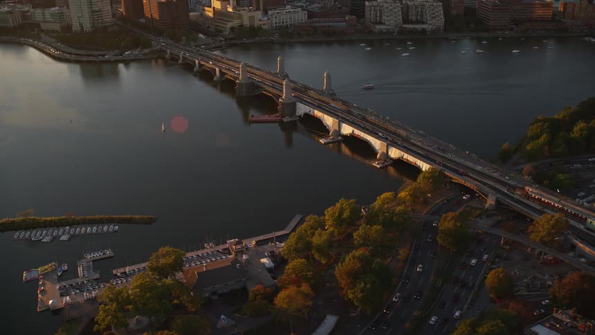 A bridge over a city river crossed by cars and a train
