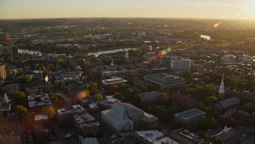 Aerial panorama of a city with a central lake and the morning sun