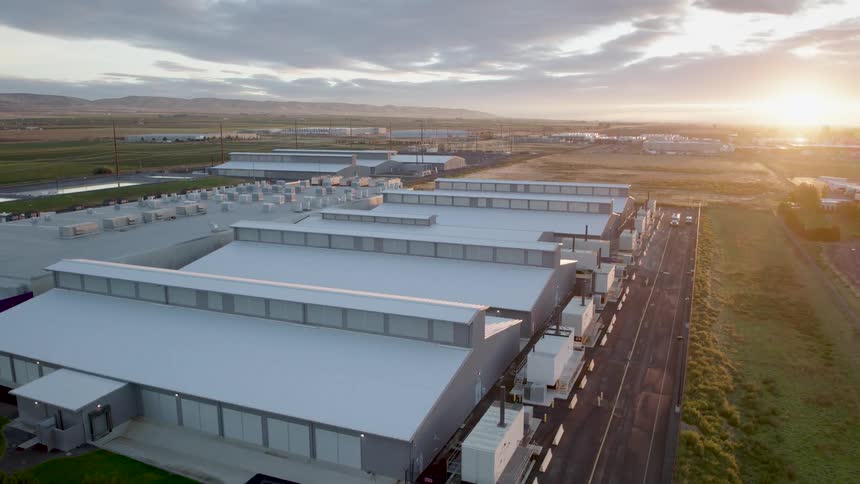 Slow approach towards a corporate data center facility as the sun rises above the horizon