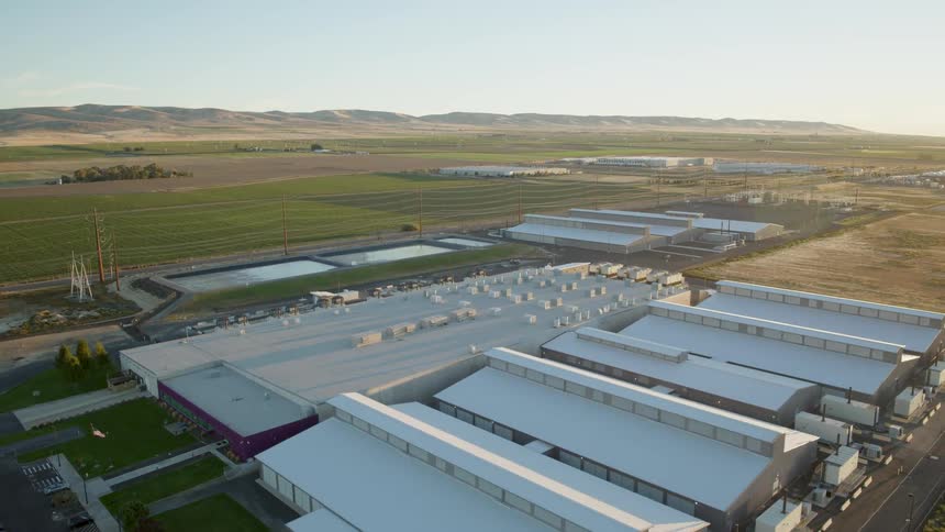 Tilt down reveal of a data center facility bathed in soft sunlight