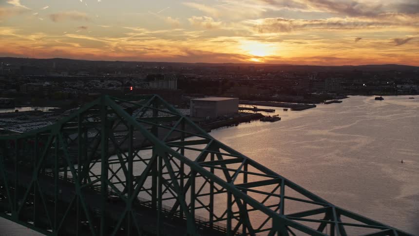 An aerial view of a large bridge across a lake with the city behind it