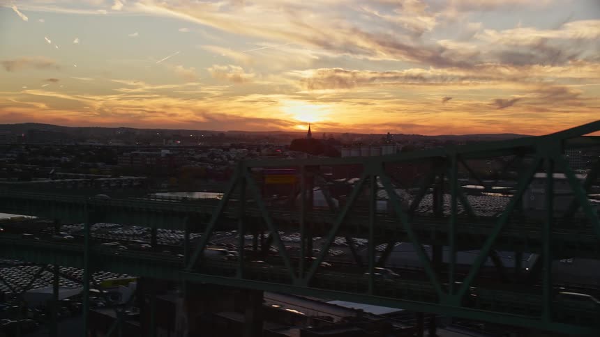 Aerial view of a bridge and city under a sunset