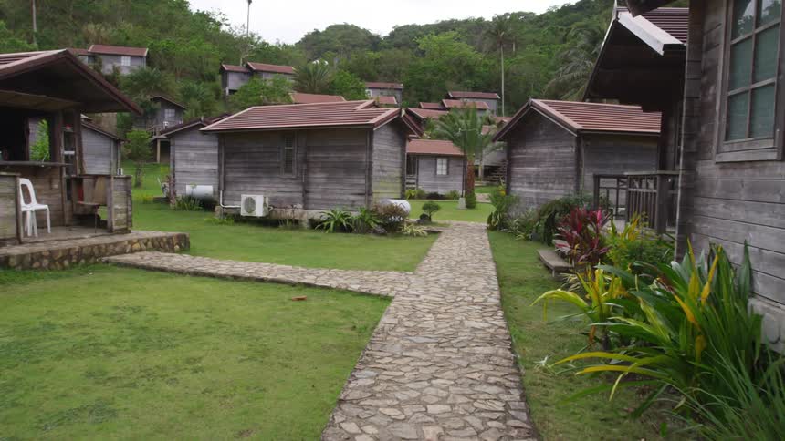 A cobblestone walkway connects a row of cottages