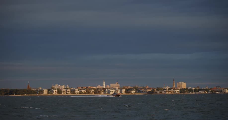Panorama of the sea with a moving boat and the city in the background