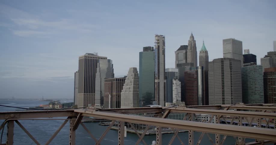 Tall buildings and skyscrapers of a coastal city stand under a cloudy sky