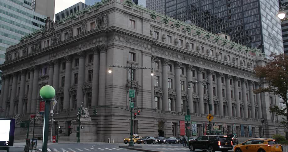 A classical building in the corner of a modern city street