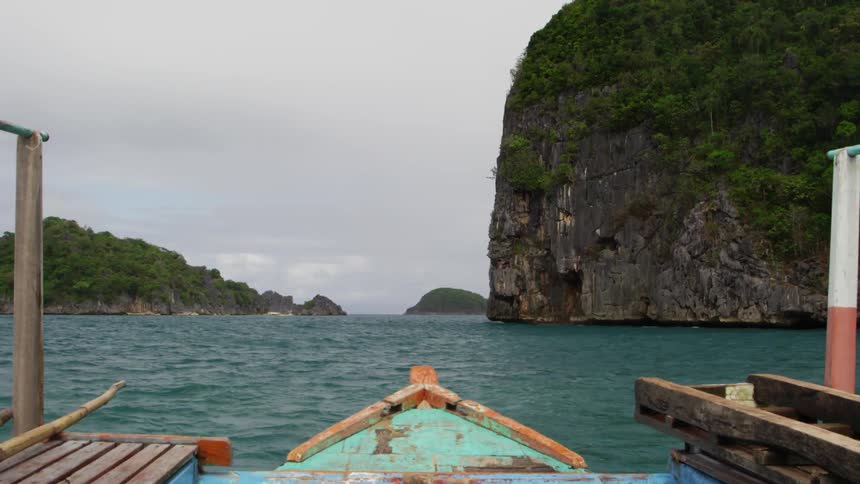A boat is moving along the water on a cloudy day