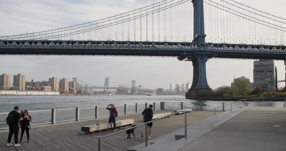 People are standing by the large bridge in the city
