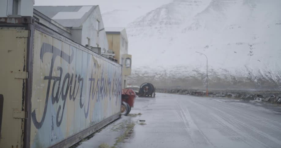 A container on the ground of a rainsoaked street