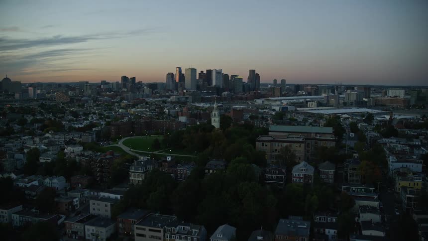 Aerial view of a waterfront city skyline at evening