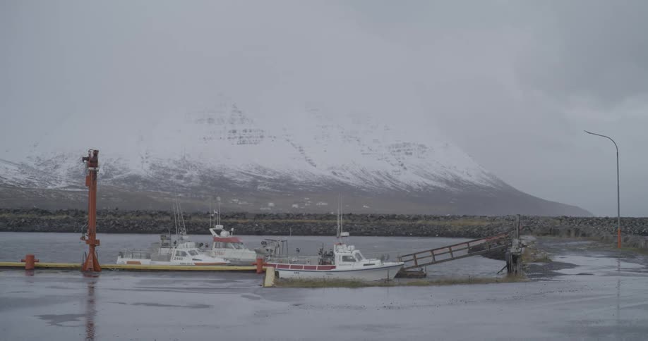 Panorama of docked boats with a backdrop of snowcovered mountain range