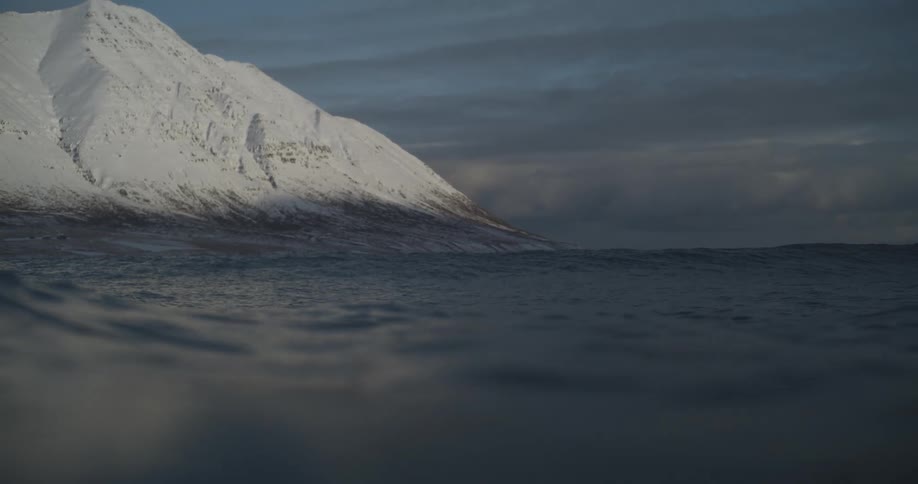 The mountain by the shore is covered in ice