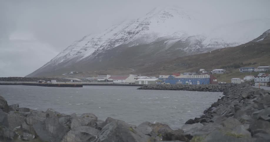 View of the seaside with houses around and snowcovered mountains