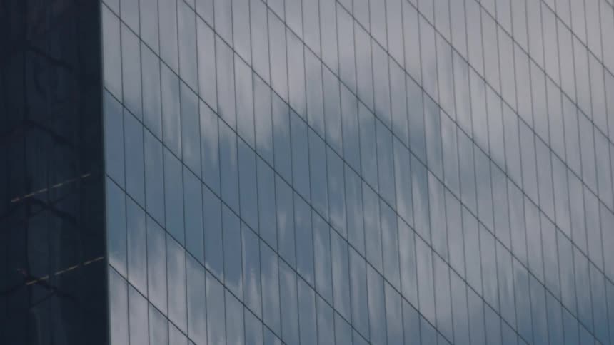 The clouds are reflecting off the building windows