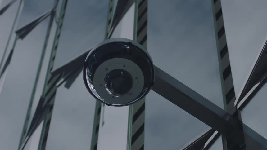 Reflective building facade reflects light around attached exterior camera