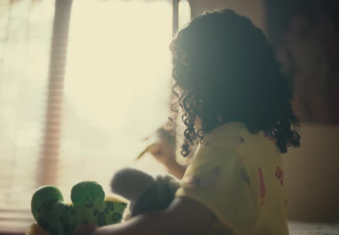 Young girl playing with her stuffed toys in a room