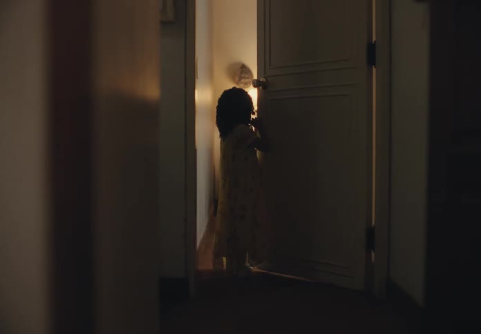 Girl walks down hallway and leans against door