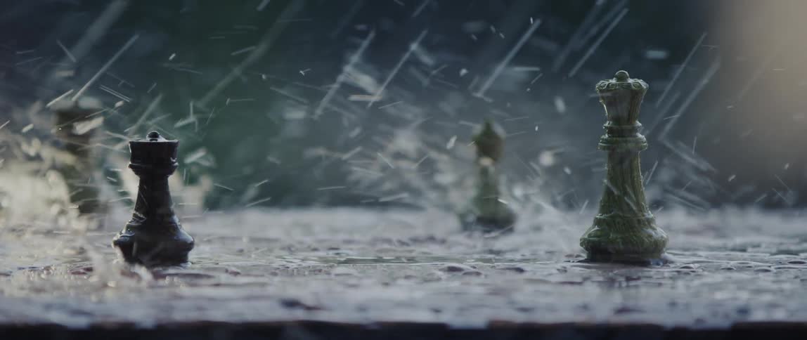 Rain falls onto chess pieces set on stone