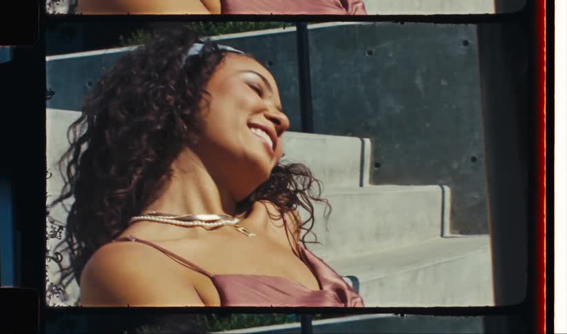 Woman modeling on a staircase wearing a blouse and necklaces
