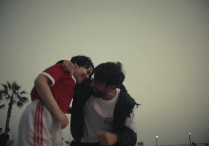 A father hugs his son in the park