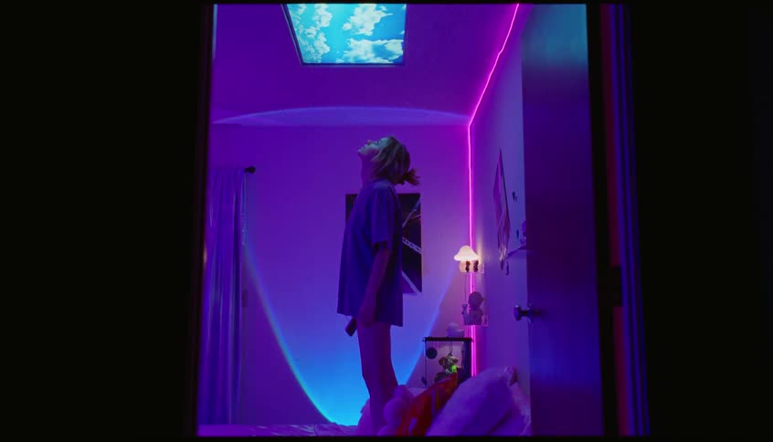 Teenager stand on the bed indoor listening to music with earpiece on