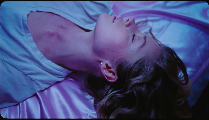 Woman lying on a mattress posing seductively and blowing a kiss