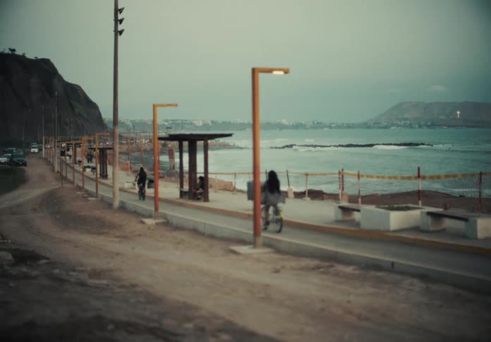 View of a beach with people riding bicycles on the waterfront