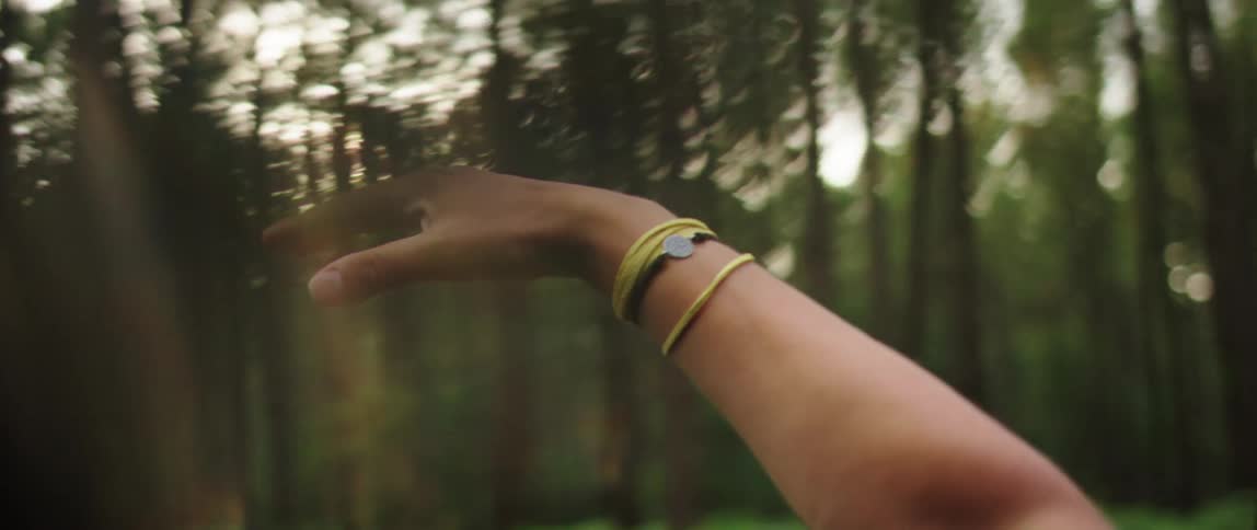 Closeup on a womans arms at the window of a vehicle with a view of a forest in slow motion