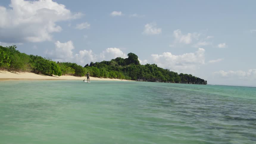 A person is paddling in the water close to shore