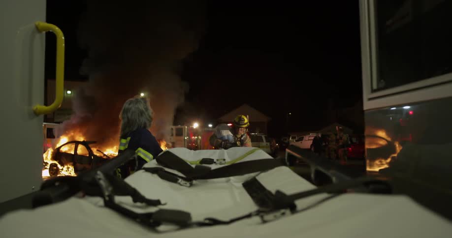 A firefighter carries a person over to a stretcher