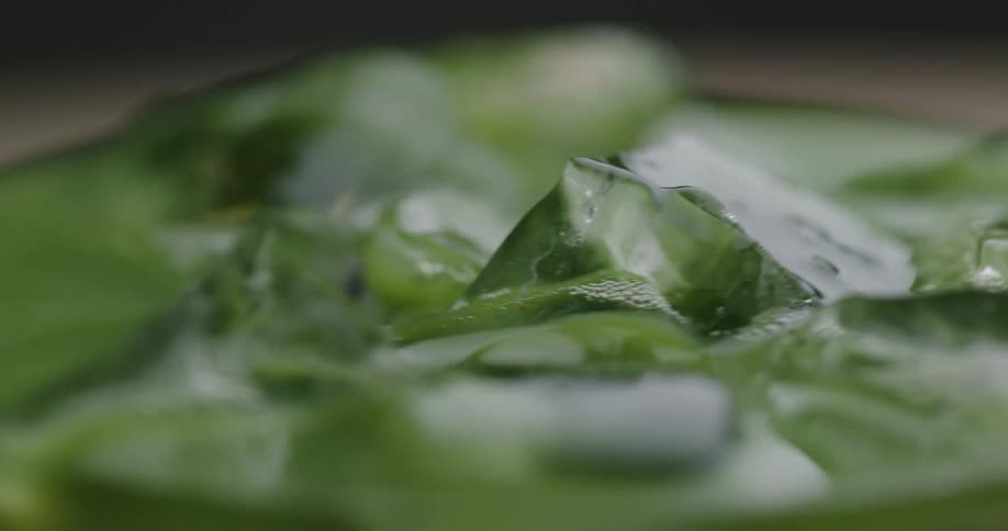 Glass with a green drink and spinning ice