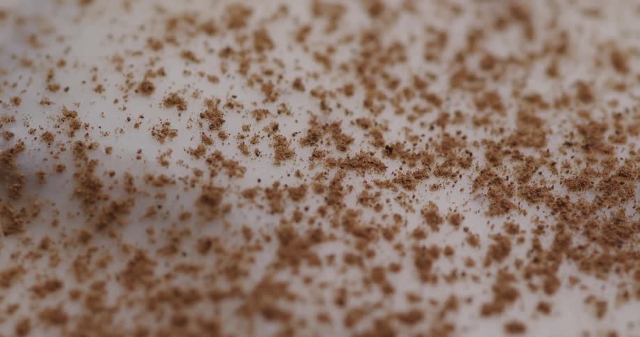 Ground spices are sprinkled onto cream