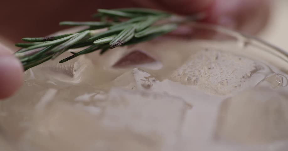 A glass of alcoholic drink with ice cubes
