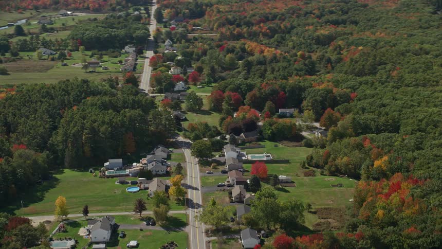 An aerial panorama of a residential neighborhood amidst vast green areas