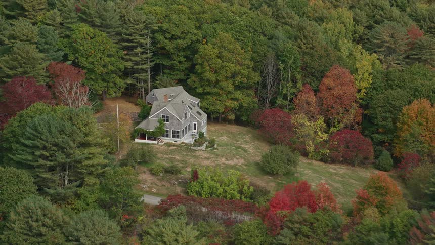 An aerial panorama of a house in the middle of a forest