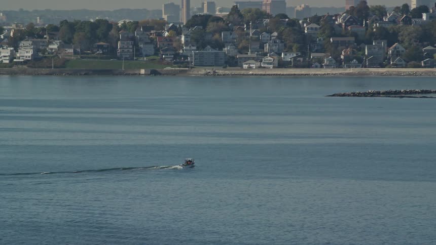 A boat sailing towards the coastal city