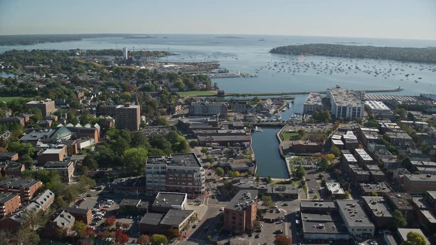 A region of a city that faces the sea with several boats parked in the water