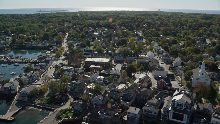 Aerial of a coastal city with streets surrounded by trees