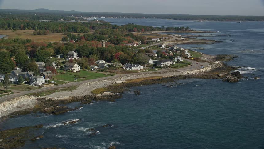 An aerial view of a road through a suburban coastal neighborhood in fall