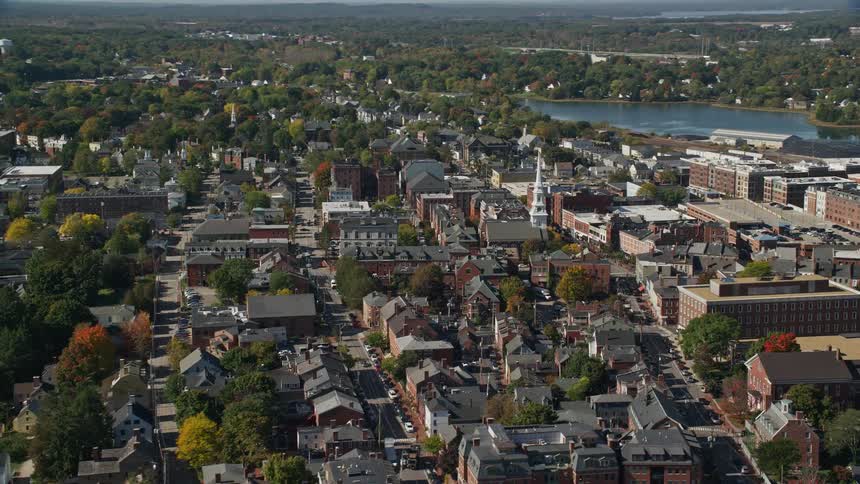An aerial shot of a small city along a river in fall