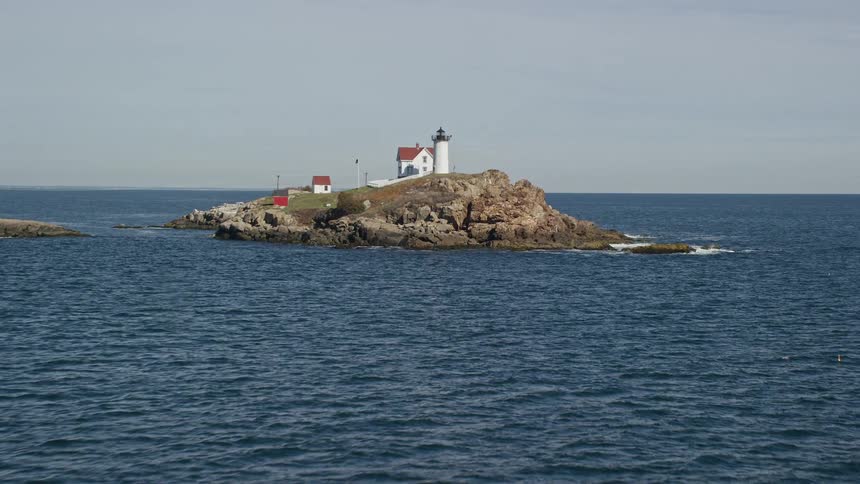 A white lighthouse on an island in the small coastal town