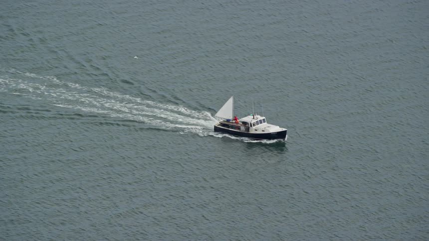 A white boat moving on the sea at midday