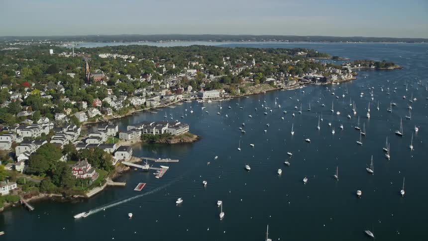 Aerial of boats and houses by the water front at midday
