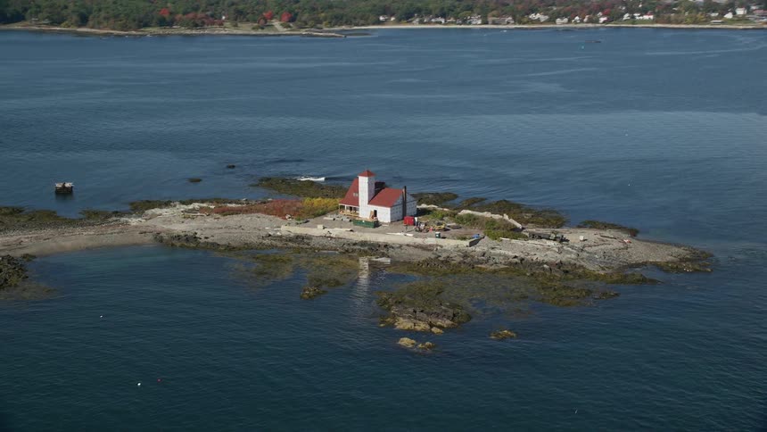 A small island with a building in the middle surrounded by a bay of water