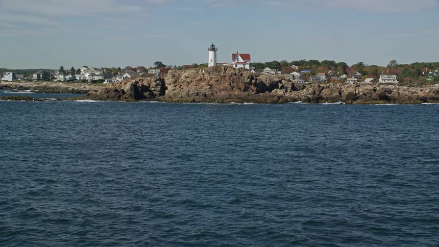 White tower on the rocks near the sea at midday