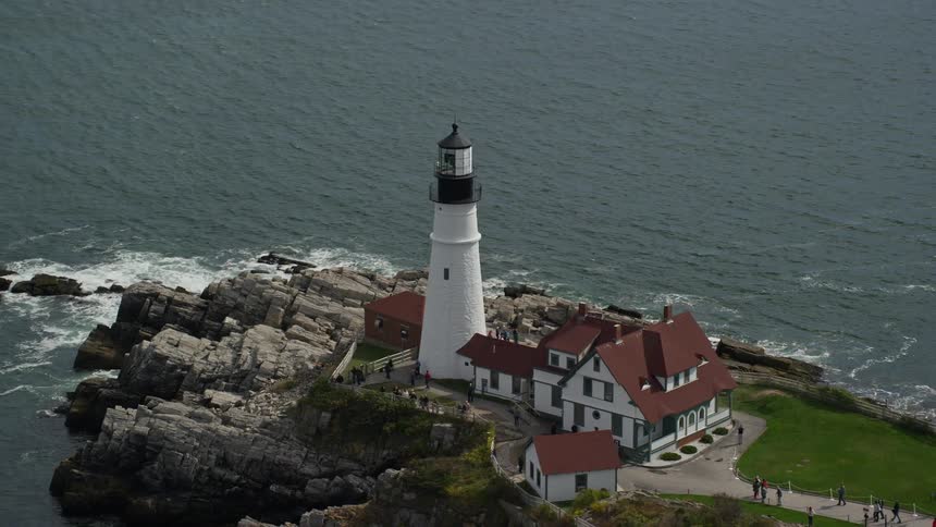 An aerial view of a lighthouse tower closer to the sea shore