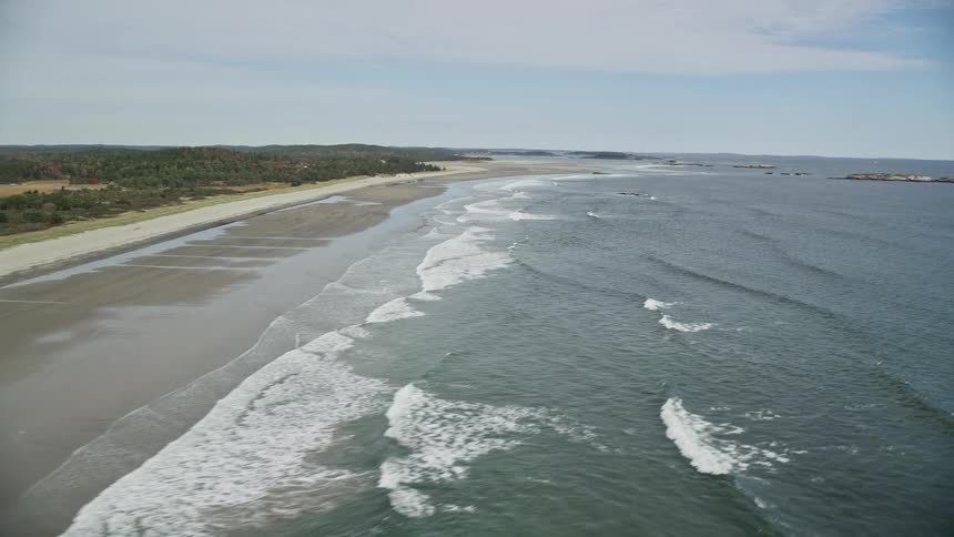 Panorama of a beach with gentle waves on a cloudy day