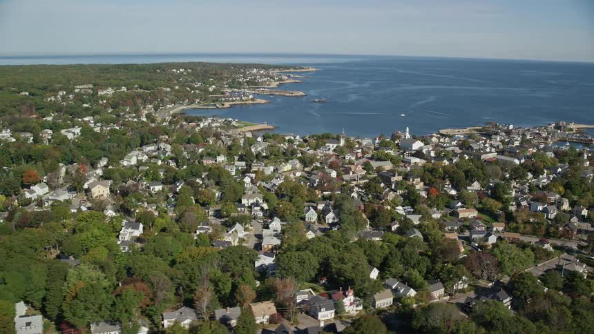 Traffic drives through wooded coastal town during early fall
