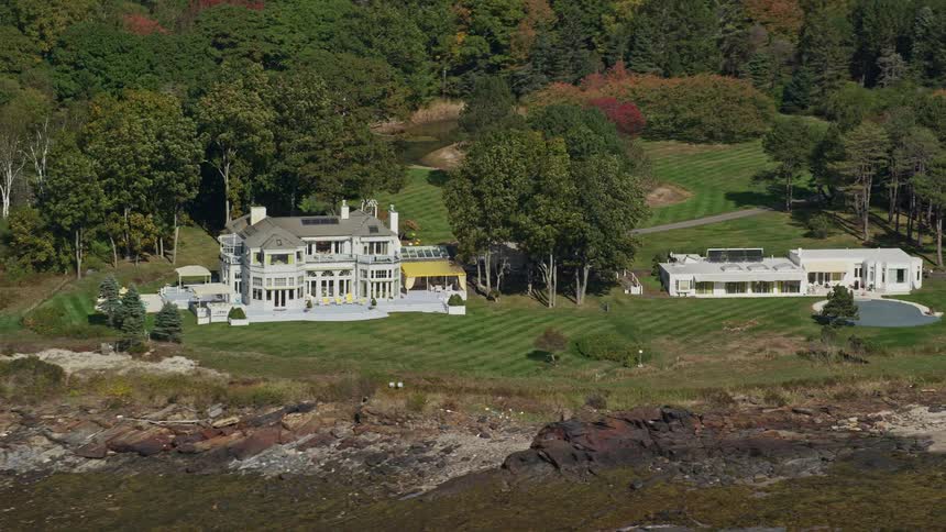 Two white house next to each other in a sub urban area with trees surrounding the area